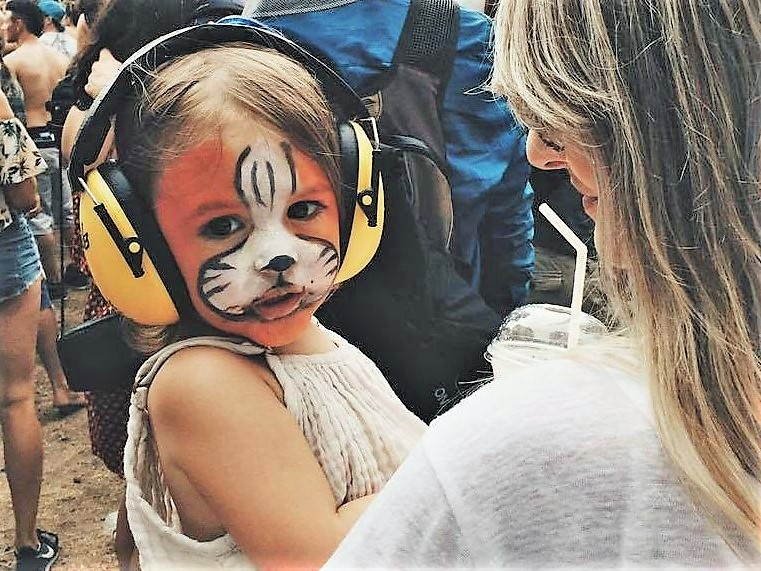Niña con cara pintada y con protectores acústicos puestos