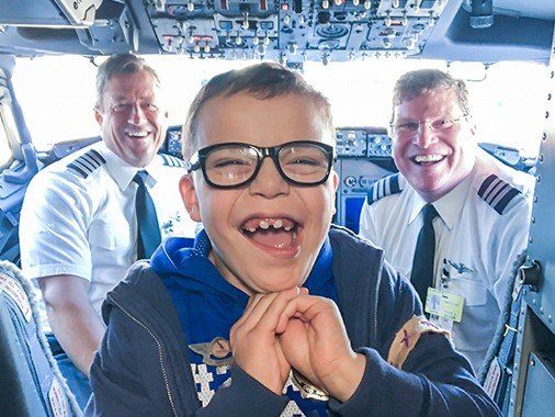 Niño felíz con pilotos dentro de la cabina
